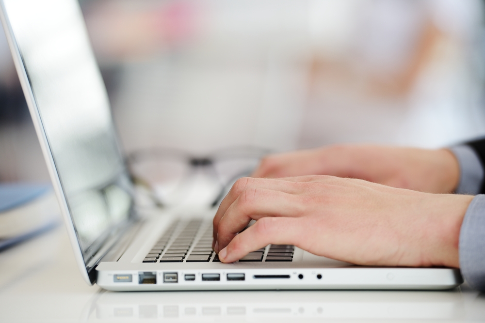 Businessman working on laptop, hands typing