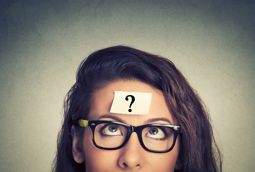 thinking woman with question mark on gray wall background thinking woman with question mark on gray wall background
